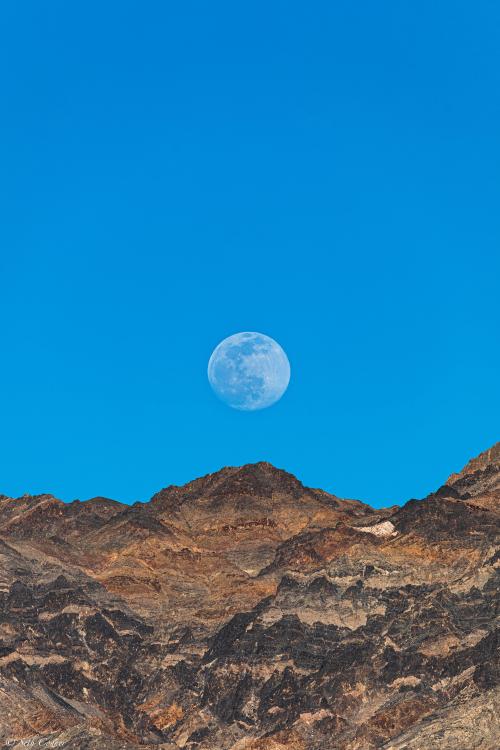 Minimalist shot of the nearly full moon rising over the Funeral Range at sunset, Death Valley, CA (O