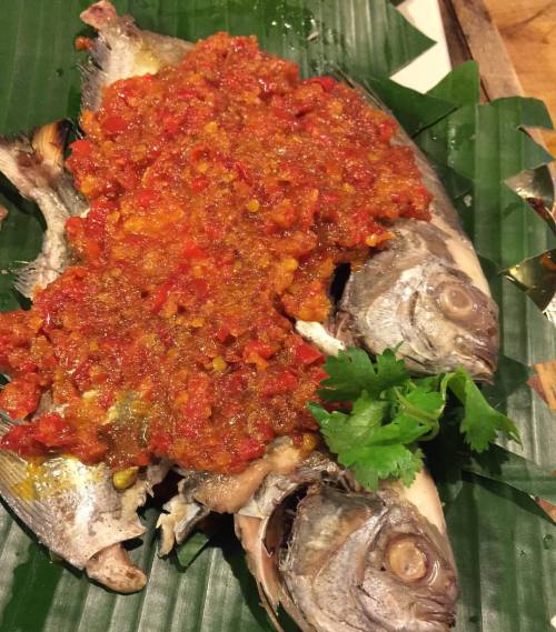 Festive red and green of sambal covered grilled fish on banana leaf. Ho! Ho! Ho! But seriously, this