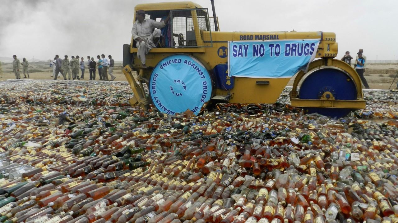 PROHIBIDO. Una apisonadora conducida por guardias costeros destruye botellas de licor el lunes 13 de noviembre de 2017, en Karachi, Pakistán. Los guardacostas paquistaníes destruyeron una gran cantidad de licor ilegal y drogas que han sido...