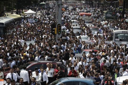 People evacuated from office buildings gather in Reforma Avenue after a 7.1 magnitude earthquake in 