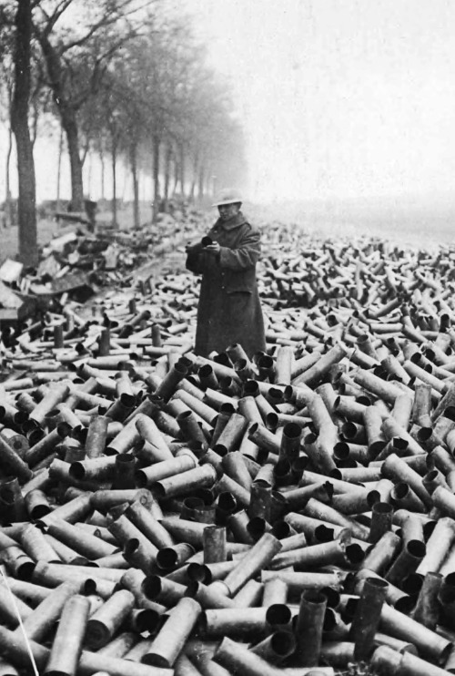 British soldier stands up to his knees in spent shell cases. France, WWI. Tom Aitken