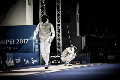 [ID: a foilist crouched, his head in his hands, as his opponent walks away.]Fencing at the 2017 Summ