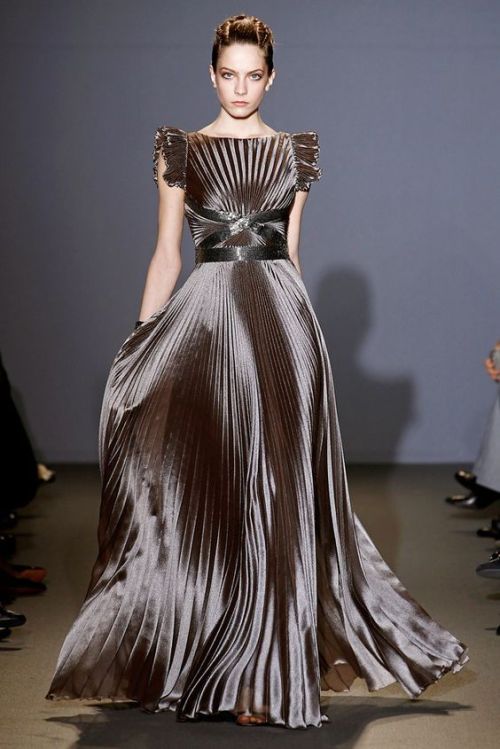 Sun-ray pleats radiate up and down from the ribbon waistline