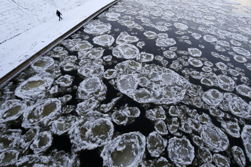 abethehero:   A pedestrian walked along the banks of the Neris river as temperatures dipped to-