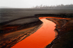 currentsinbiology:  “Nickel Tailings #34,” Sudbury, Ontario, Canada, 1996 Tailings are the materials left over after the process of separating the valuable portion from the “unwanted” portion of an ore. The bright orange in the above photo is