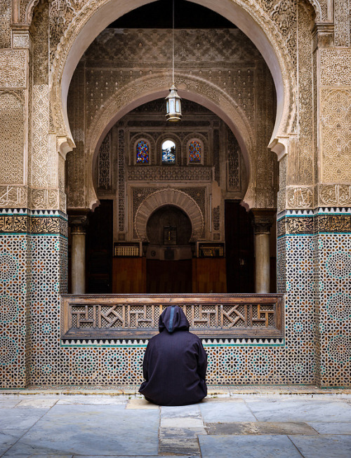 Morocco.Fez.Man seating at the courtyard of the Al Attarine Madrasa 