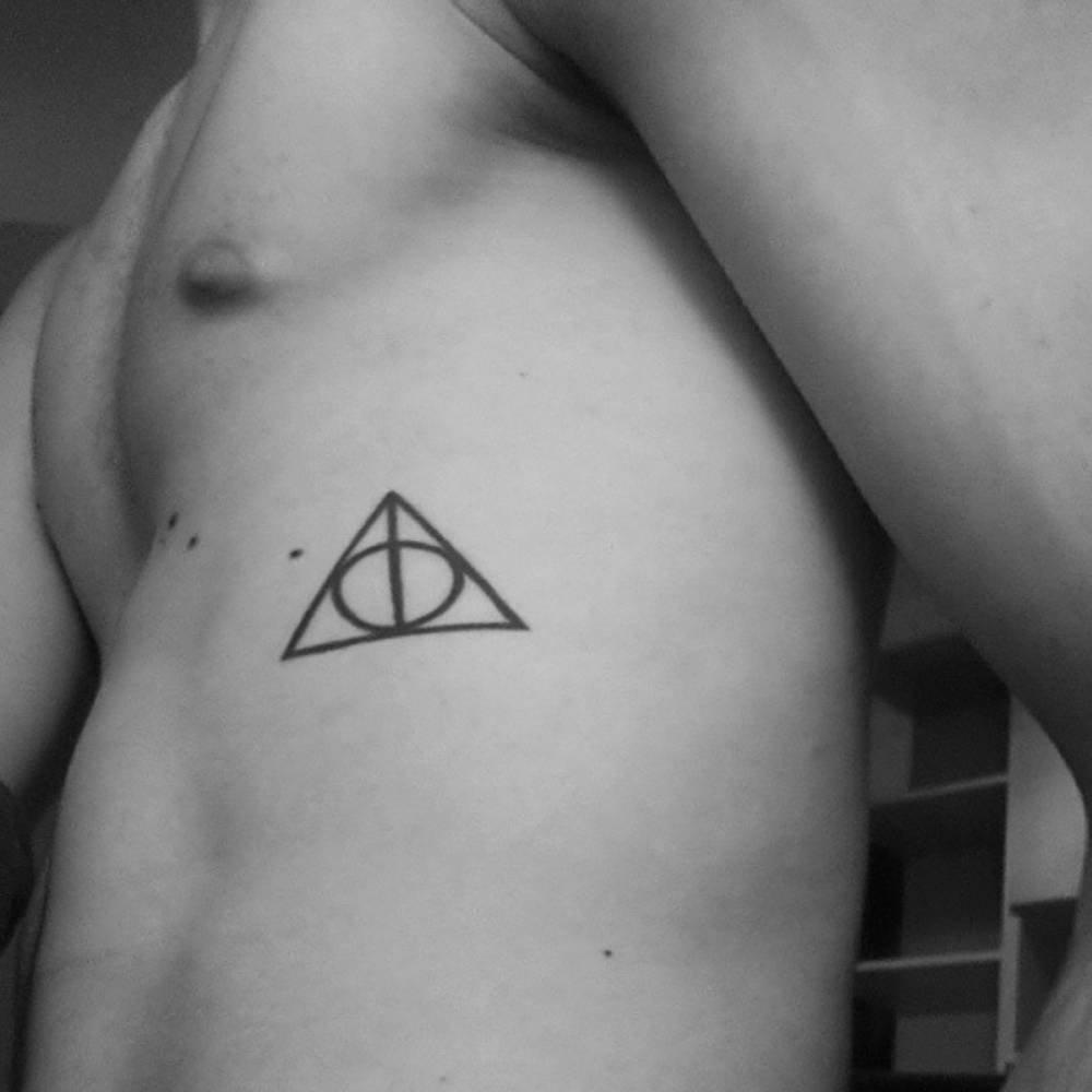 pequenostatuajes:  Tatuaje de las reliquias de la muerte de Harry Potter en el costado