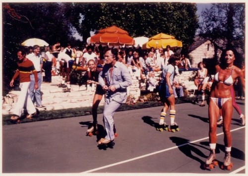 Captured roller skating and talking to friends, Hugh Hefner enjoys his 1979 Playboy Mansion Roller p