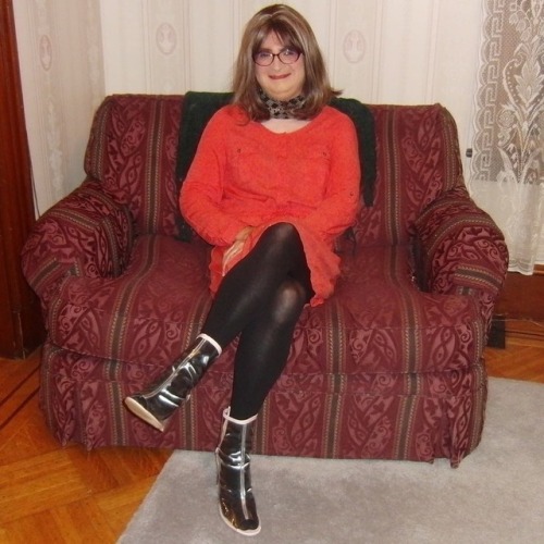 Full-length picture of me, seated, facing forward, legs crossed, wearing my new purple cat-eye glass