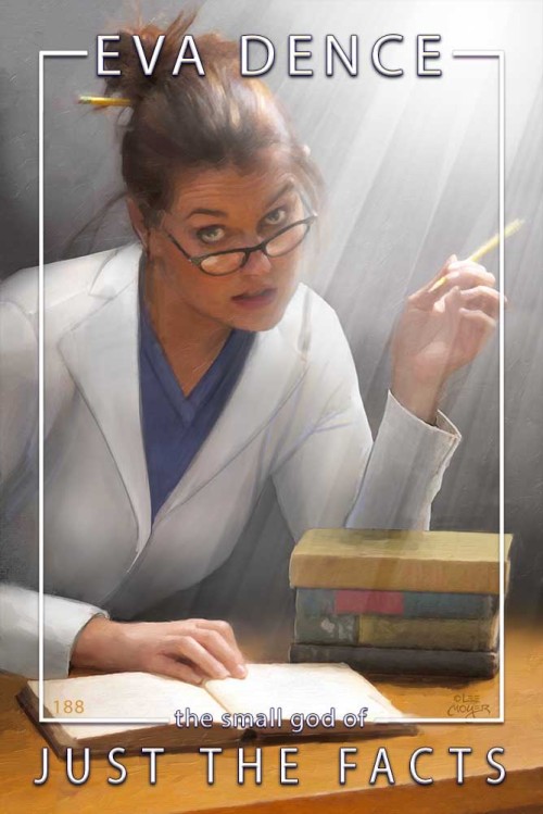 [image description: A woman in a blue tunic and a white lab coat sits at a desk, one hand on an open