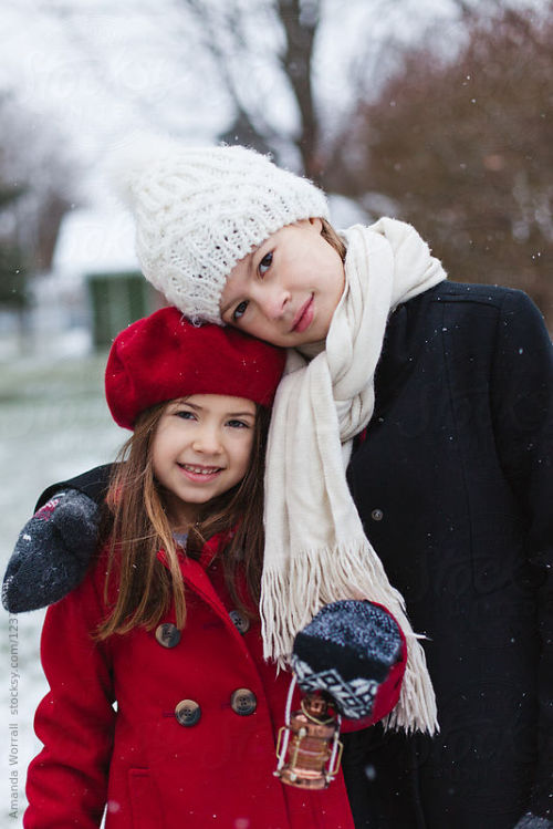 Sisters hugging outdoors in the winter By goodnessgraceAvailable to license exclusively at Stocksy