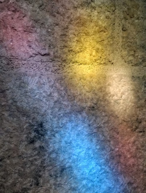 Sunlight streams through a stained glass window in Glencairn’s library, bathing granite walls 