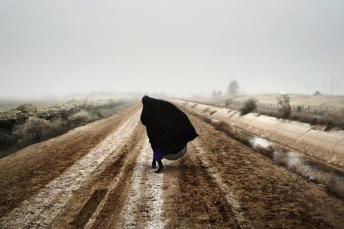 killing-the-prophet:An Iraqi woman walks on a road south of Baghdad, Dec. 20, 2002, prior to the U.S