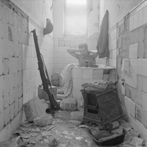 historicaltimes:A British soldier takes advantage of the opportunity to have a bath in Tobruk, Libya