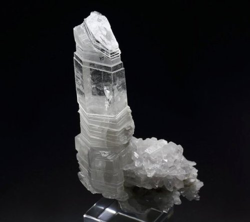 hematitehearts:  Quartz   Bizarre specimen of Quartz crystal sliced by thin Calcite layers from Bor Pit, Dal negorsk, Russia. It forms an aesthetic cluster of Quartz with one dominant crystal. It has sharp hexagonal shape and irregular thickness due