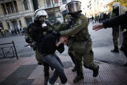 SURROUNDED: Police detained a protester in Athens Thursday. Students marched in memory of Alexis Grigoropoulos, 15 years old, who was fatally shot by police in December 2008 amid Greek riots. (Angelos Tzortzinis/AFP/Getty Images)