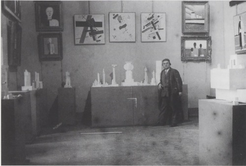Kazimir Malevich stands at the fifteen-year revolutionary retrospective of his work, 1917-
