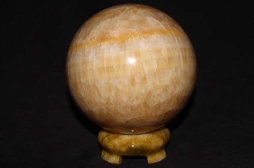 A moon?  A planet?  No, it’s a 4-inch orange calcite sphere, pictured under short wave ultraviolet, 