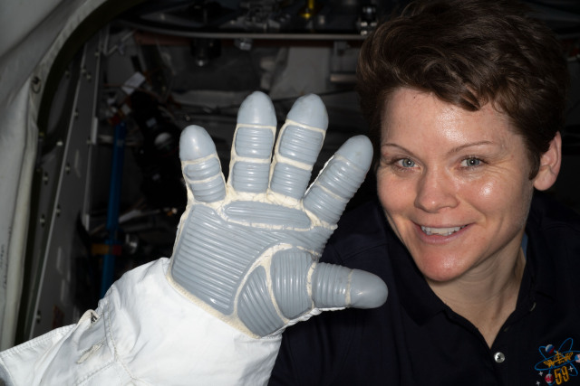 NASA astronaut Anne McClain displays a U.S. spacesuit glove that consists of several layers for extra thermal protection and comfort. Thermofoil heaters are also attached inside each of the fingertips in one of the layers of the glove.