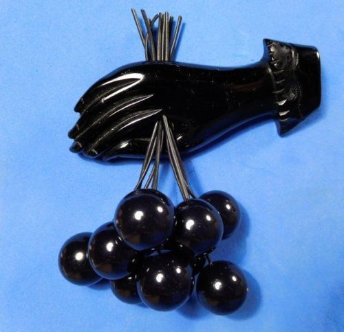 wike-wabbits:Bakelite brooch, black hand with 9 dangling cherries (1940s)