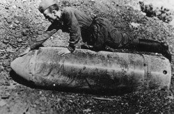 historicaltimes:  Soviet soldier next to unexploded German shell in Sevastopol, June 1942 via reddit