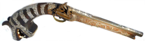 Indian flintlock pistol with tiger head buttstock.  Tiger carving includes real tiger teeth.