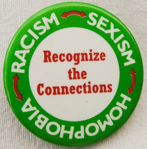 “RACISM <—> SEXISM <—> HOMOPHOBIA: RECOGNIZE THE CONNECTIONS” pinback, manuf