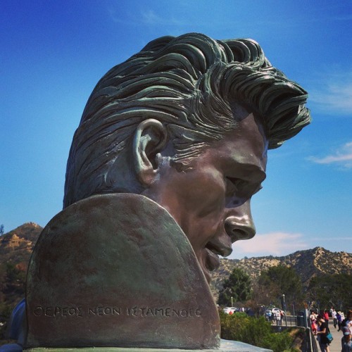 Who is in the photo at the famous landmark in Los Angeles and what is written on the monument?