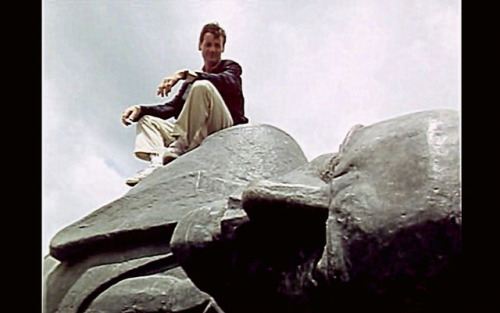 Palin sitting on a late Lenin statue, toppled, lying on the ground of Ethiopia.