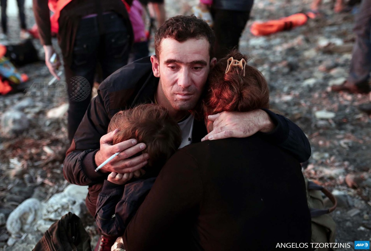 afp-photo:  GREECE, Kos : A migrant man hugs his family upon reaching the Greek 