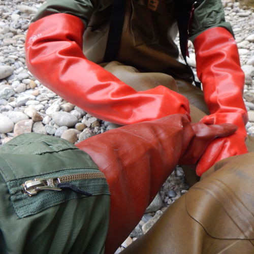 Two bomber guys meeting in chest-high rubber boots and arm-long rubber gloves