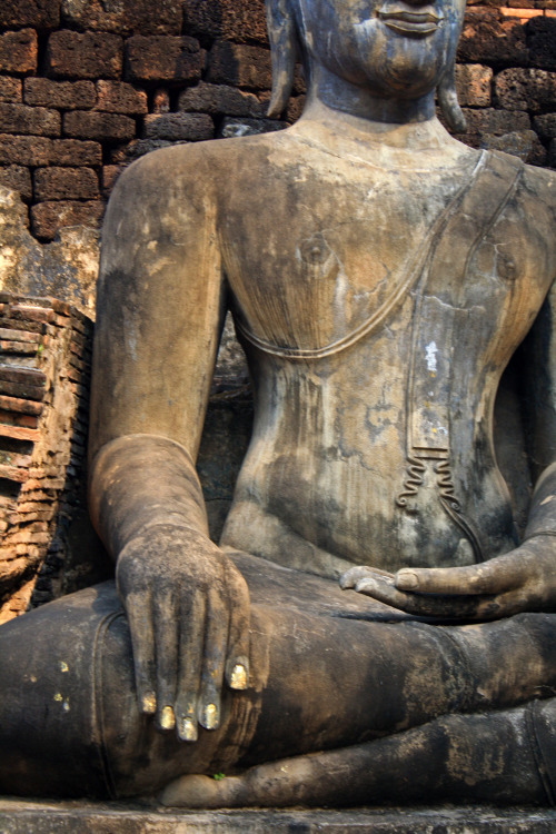 A Buddha statue with gold-painted fingernails.