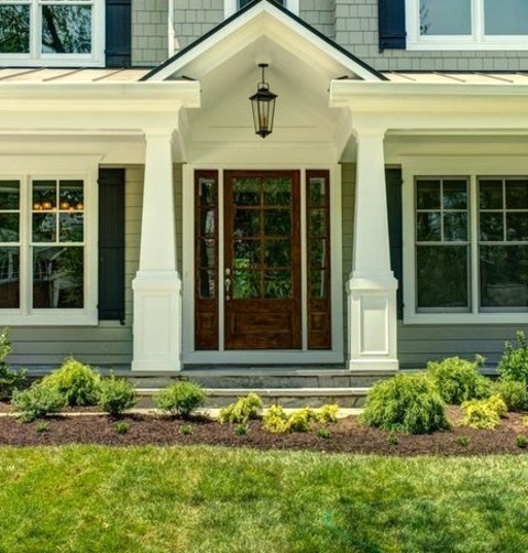 Front Yard PorchAn Example Of A Large Traditional Stone Front Porch Design With A Roof Extension.