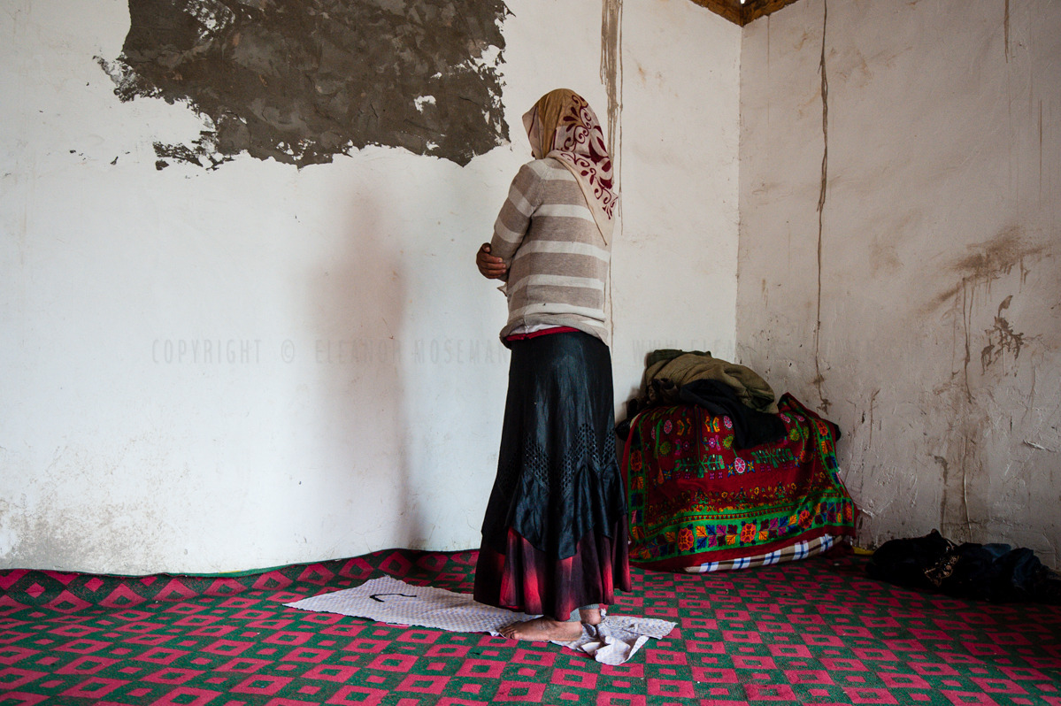 A Uyghur woman prays towards Mecca in her home. Uyghurs, as all Muslims, pray at least 5 times a day. Near Kasghar, 2012