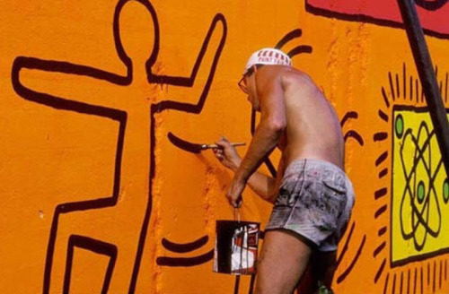 twixnmix: Keith Haring painting a mural on Houston Street and Bowery in New York City, 1982.  