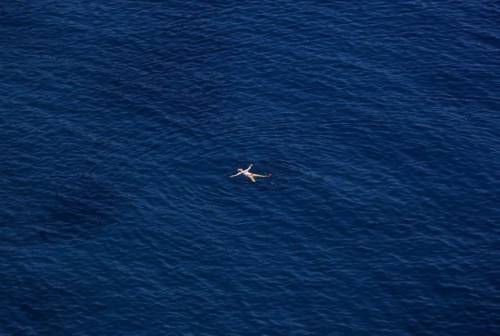 slanting:  A fine day for a float in the Aegean sea: A German tourist bathes in the Aegean sea in Arcadia prefecture on the east coast of Paloponnese south of Athens July 3, 2013. (source)