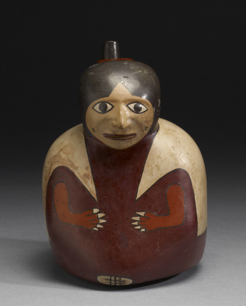 Effigy vessel depicting a seated figure wearing a long tunic, of the Nasca (Nazca) culture of what i