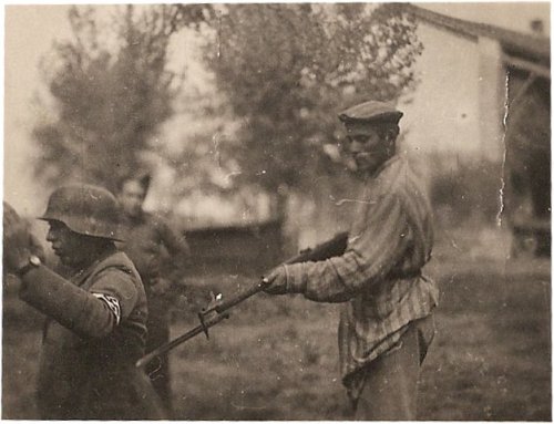 Concentration camp inmate holds his former guard at gunpoint at the end of World War II.