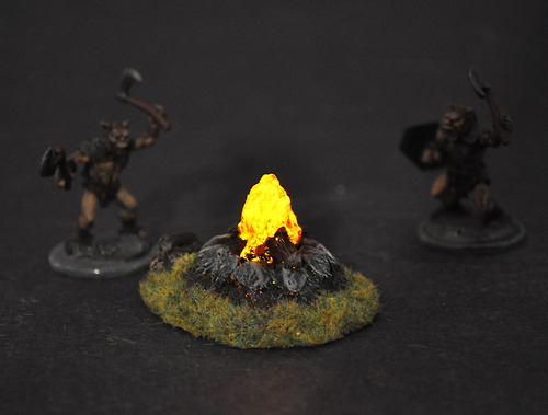 sturmtruppen:  two-bugbears:  These are small, light up camp fires we make for miniature war gaming and role playing games. They are in the 28mm scale, and flicker and provide a scale light source that looks fairly realistic on the tabletop. We thought