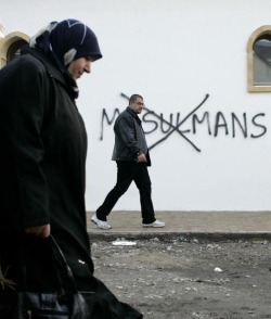 na3saan:  fnhfal:  Muslim residents walk past slurs painted on the walls of a mosque in the town of Saint-Etienne, in central France.  Thats sad 