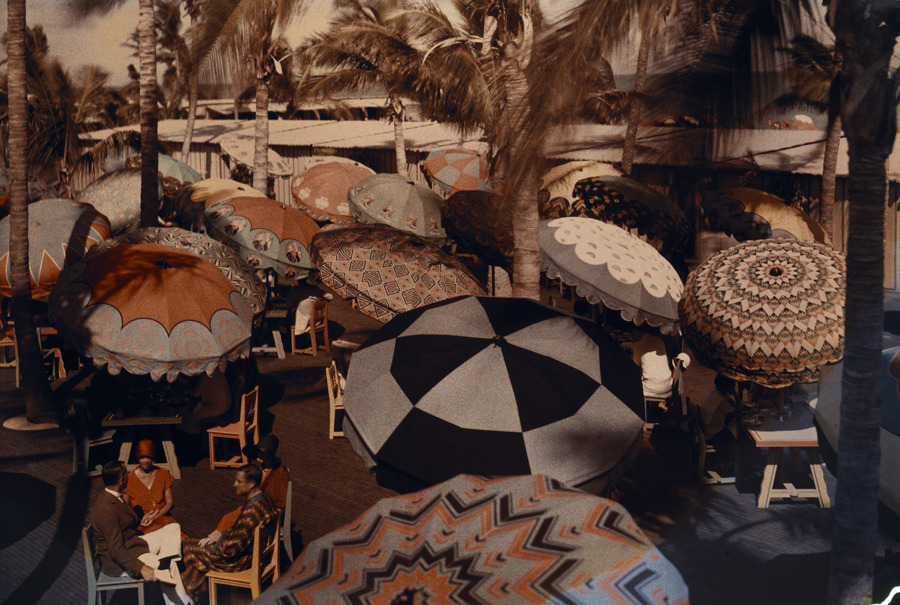 natgeofound:  Club members on the ocean front are shaded by decorative parasols,