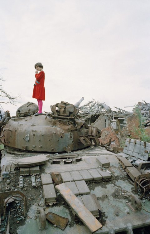 konflict23:A Chechen girl on a Russian tank destroyed by Chechen fighters. Grozny, Chechnya, 1996.