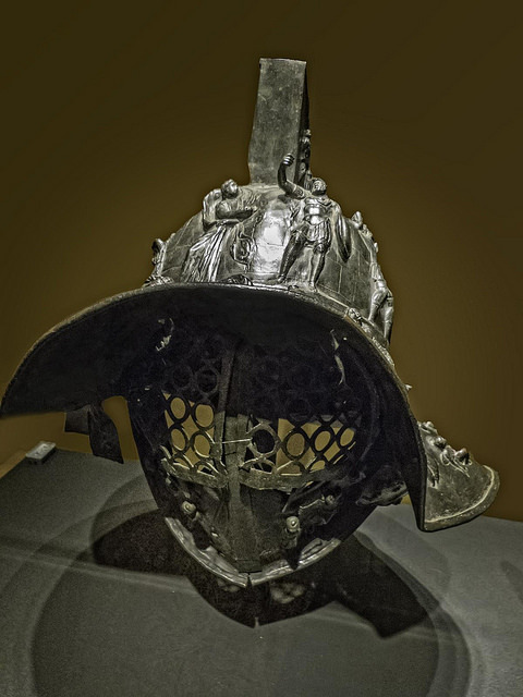 Myrmillo-style bronze gladiator helmet with bas-relief depicting scenes from the Trojan War Herculan