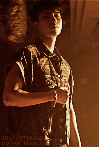 Harin looking down at the camera holding his arm up by his side