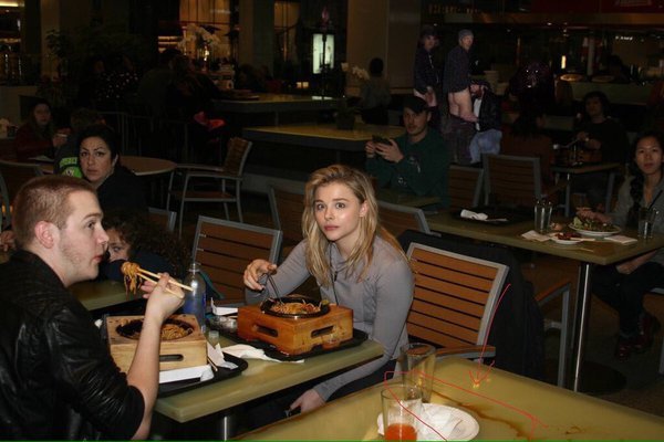  why chloe moretz eating spaghetti from wooden boxes?why everyone lookin in the camera??WHY