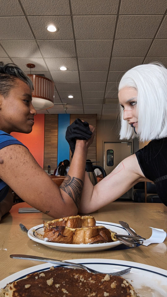 Arm wrestling for the bill in goth girl IHOP.