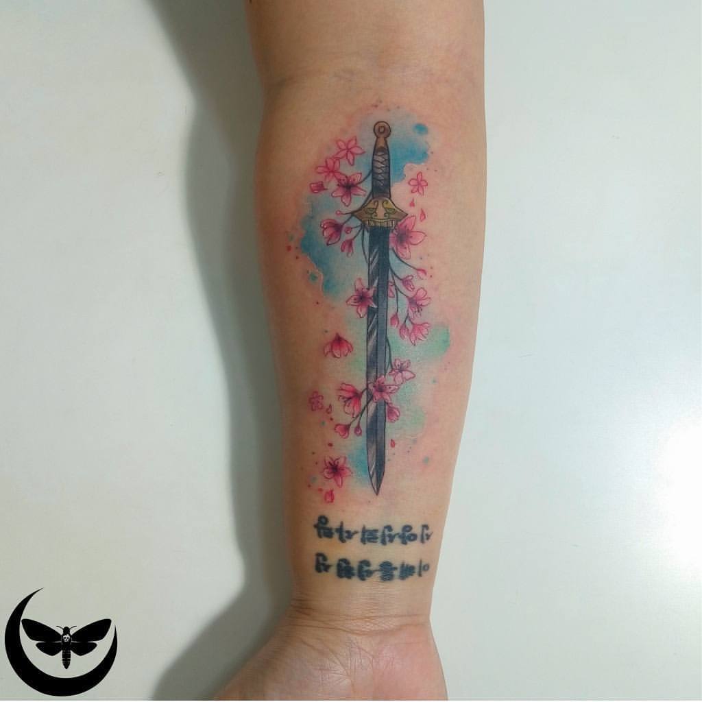 Mulans sword tattooed on the forearm