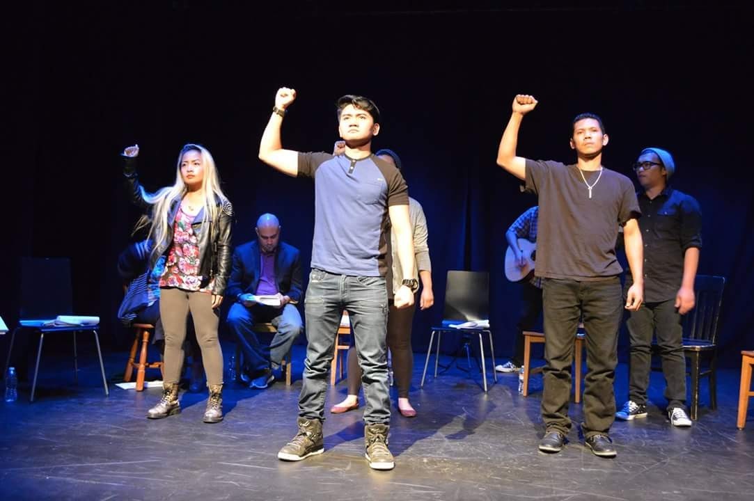 Pictured: The staged reading cast of WELGA with fists raised as performed at Z Below in SF produced by SFSU, Greenhouse Festival.