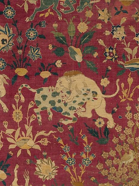 Lion biting into a green spotted cow, from a silk rug with animals in combat, probably made in Kasha