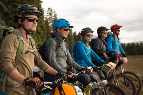 image of five cyclists in a line looking out at the mountains